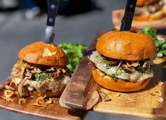 NOLA Burger with green onion dressing, crispy shallots, cheddar, French fries at The Rock & Rye at Sweetwater Music Hall