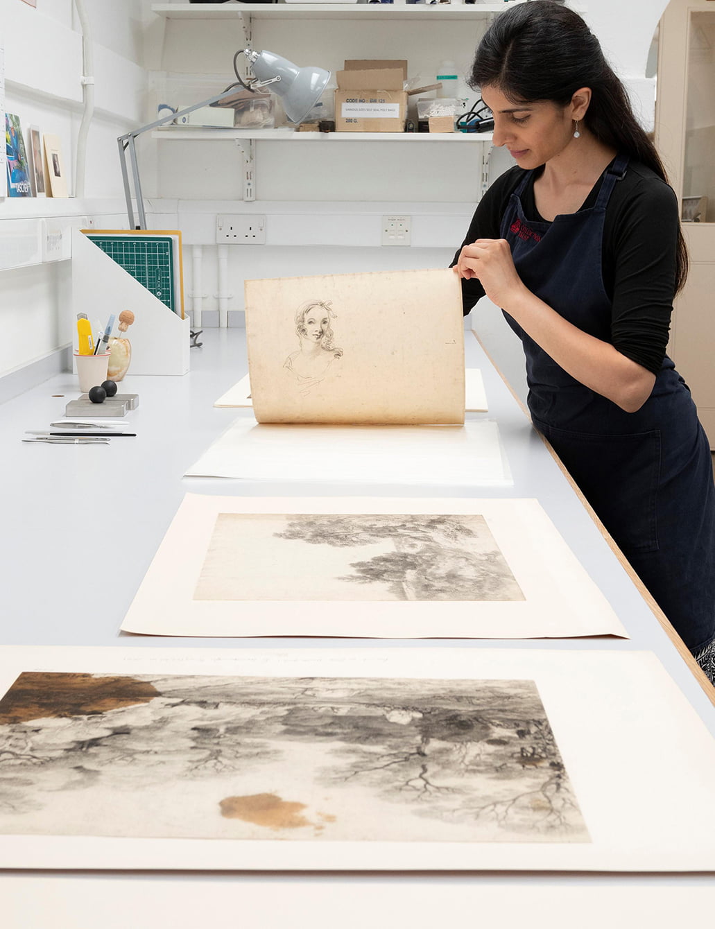 When Royal Collection Trust conservators at Windsor Castle removed Gainsborough’s drawings from their album they found that some had drawings underneath. Paper Conservator Puneeta Sharma lifts up a drawing of a pond to reveal a study of a young woman on the other side, drawn in the slightly naïve figure style of Gainsborough’s early portraits.