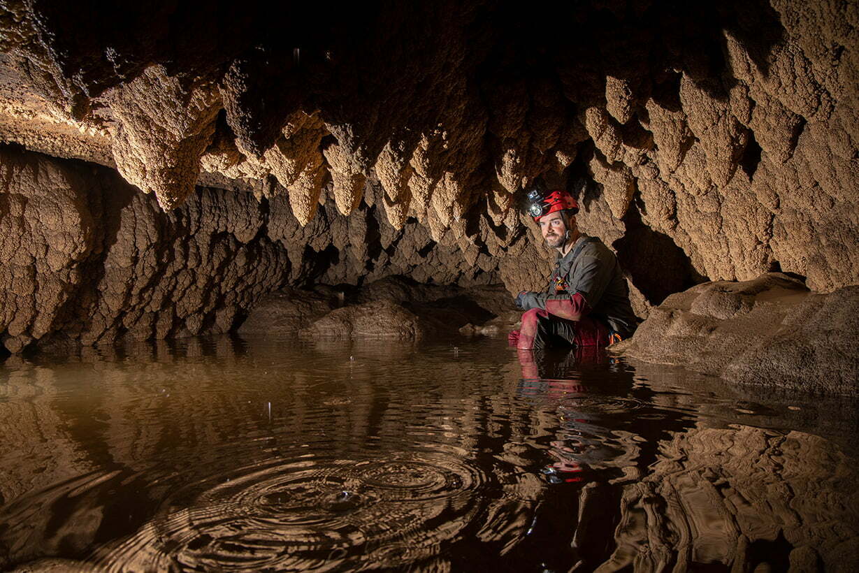 Brad Wuest at the back of the pool at the bottom of the northern passage in Wild Cave. This pool can fill during wet weather.