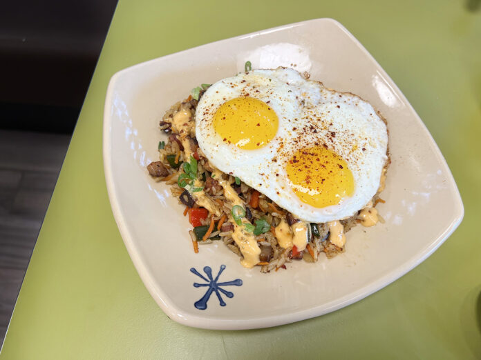 Habanero Pork Belly Breakfast Fried Rice: Jasmine fried rice with seared cider-braised habanero pork belly, sautéed red bell peppers, onions, poblanos, carrots and pineapple. Topped with a drizzle of house-made Sriracha maple aioli, two crispy sunny-side up eggs, scallions and kimchi spice. - Snooze Huntington Beach, California (Photo by Julie Nguyen)