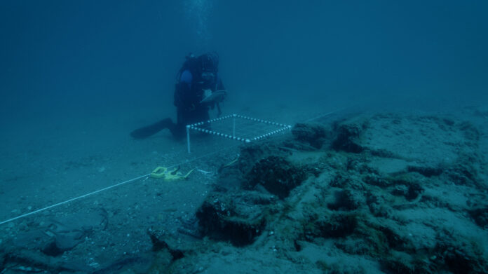 Michigan's State Maritime Archaeologist Wayne R. Lusardi takes notes underwater at the site of the wreck of a P-39 airplane lost in the waters of Lake Huron in 1944.