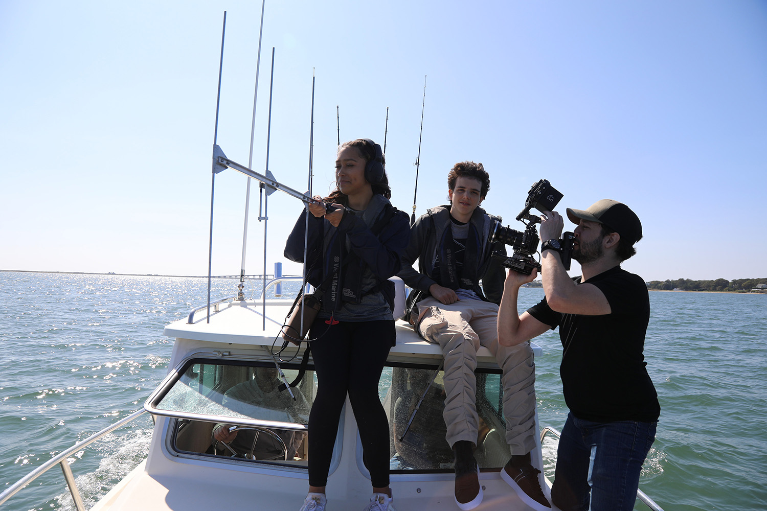 BTS of students Beckham La Rose and Kaelyn Heits using tracking equipment on board boat.
