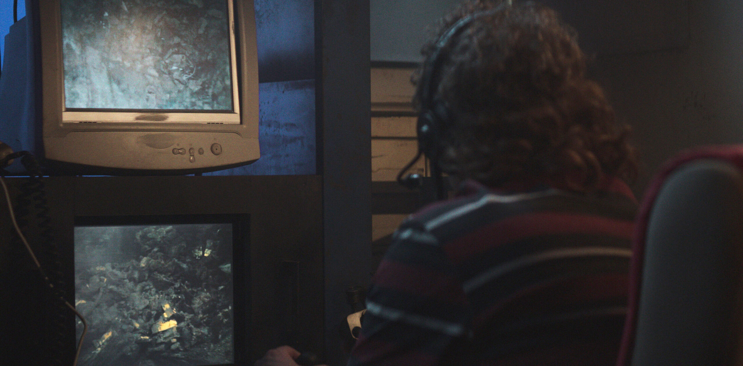 A dramatic reconstruction for "Cursed Gold: A Shipwreck Scandal" shows a crew member looking at computer screens in the ship's control room. In 1989, maverick scientist Tommy Thompson, stuns the world by recovering three tons of gold from a shipwreck deep in the Atlantic Ocean. What follows is a 30-year story of adventure, deception, and personal turmoil, taking him from venerated celebrity to infamous fugitive, and finally a defiant prisoner who refuses to give up his gold. (National Geographic)