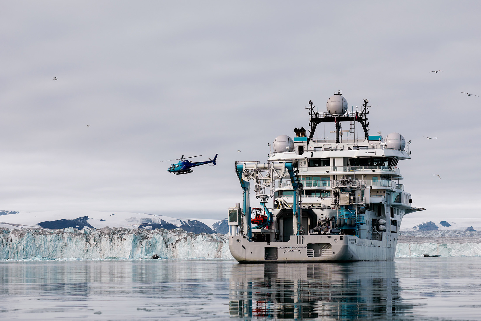 The helicopter flies away from the OceanXplorer.