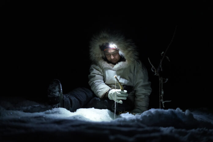 Agnes Hailstone ice fishes with her family on the frozen river late at night.