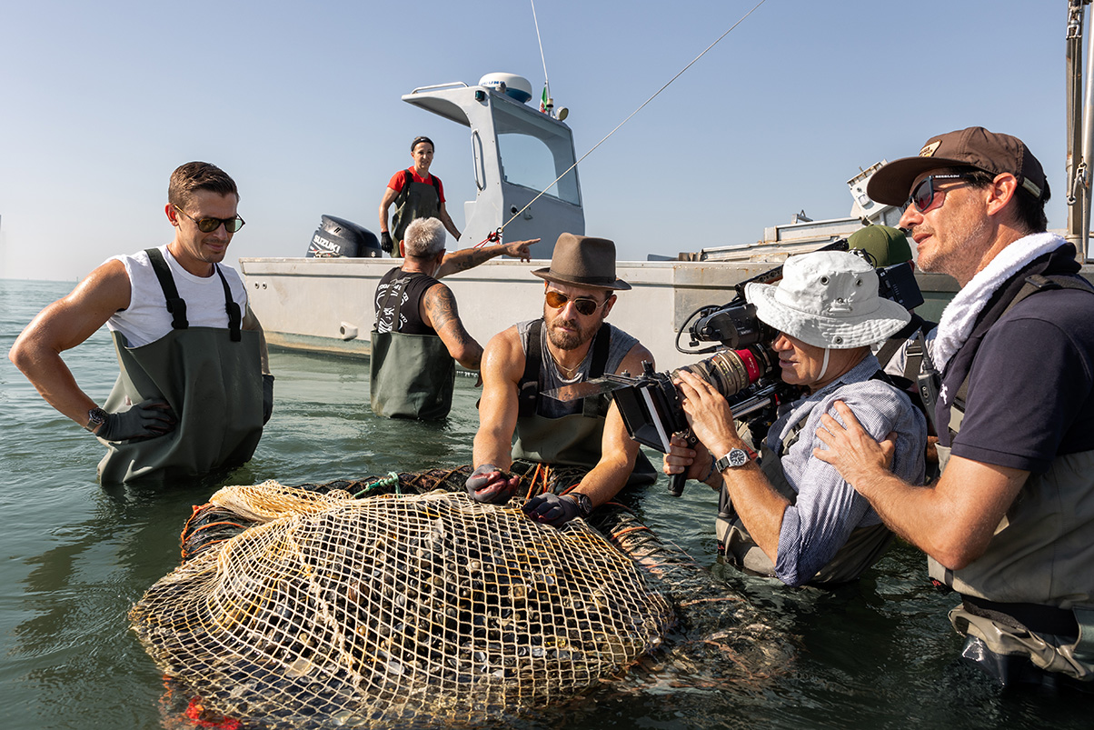 Behind-the-scenes of Antoni Porowski and Justin Theroux harvesting clams from the Po River alongside Simona and Germano.