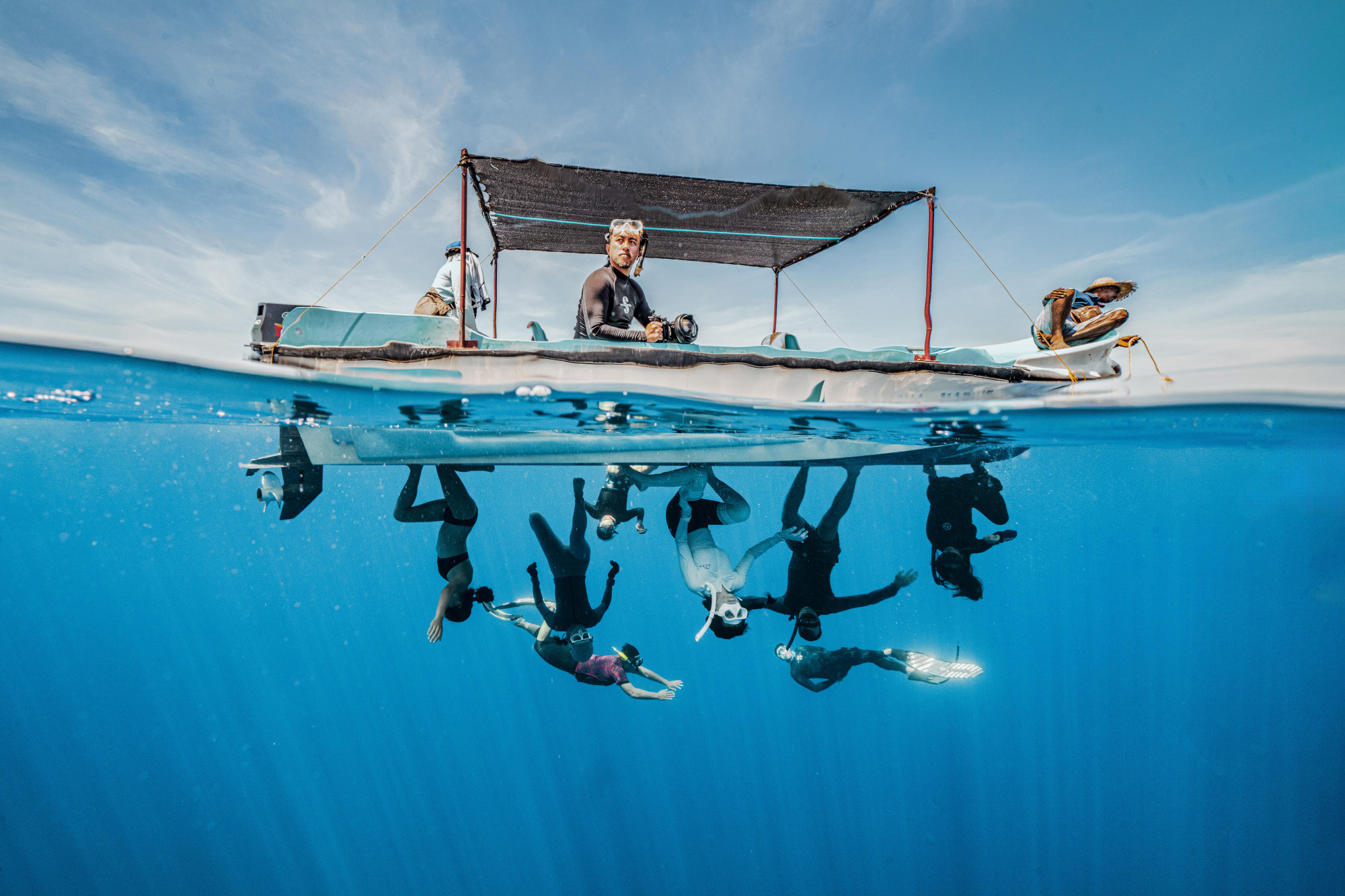 In this photograph, a group of freedivers skilfully defy gravity, suspended upside down beneath a boat in clear water. Their silhouettes create a mesmerising scene that is reminiscent of the ‘Spider-Verse’; their forms seem to dance in harmony with the underwater world, blending the artistry of human movement with the fluidity of aquatic life.

Copyright: © Wan Yong Chong, Malaysia, Winner, National Awards, Sony World Photography Awards 2025