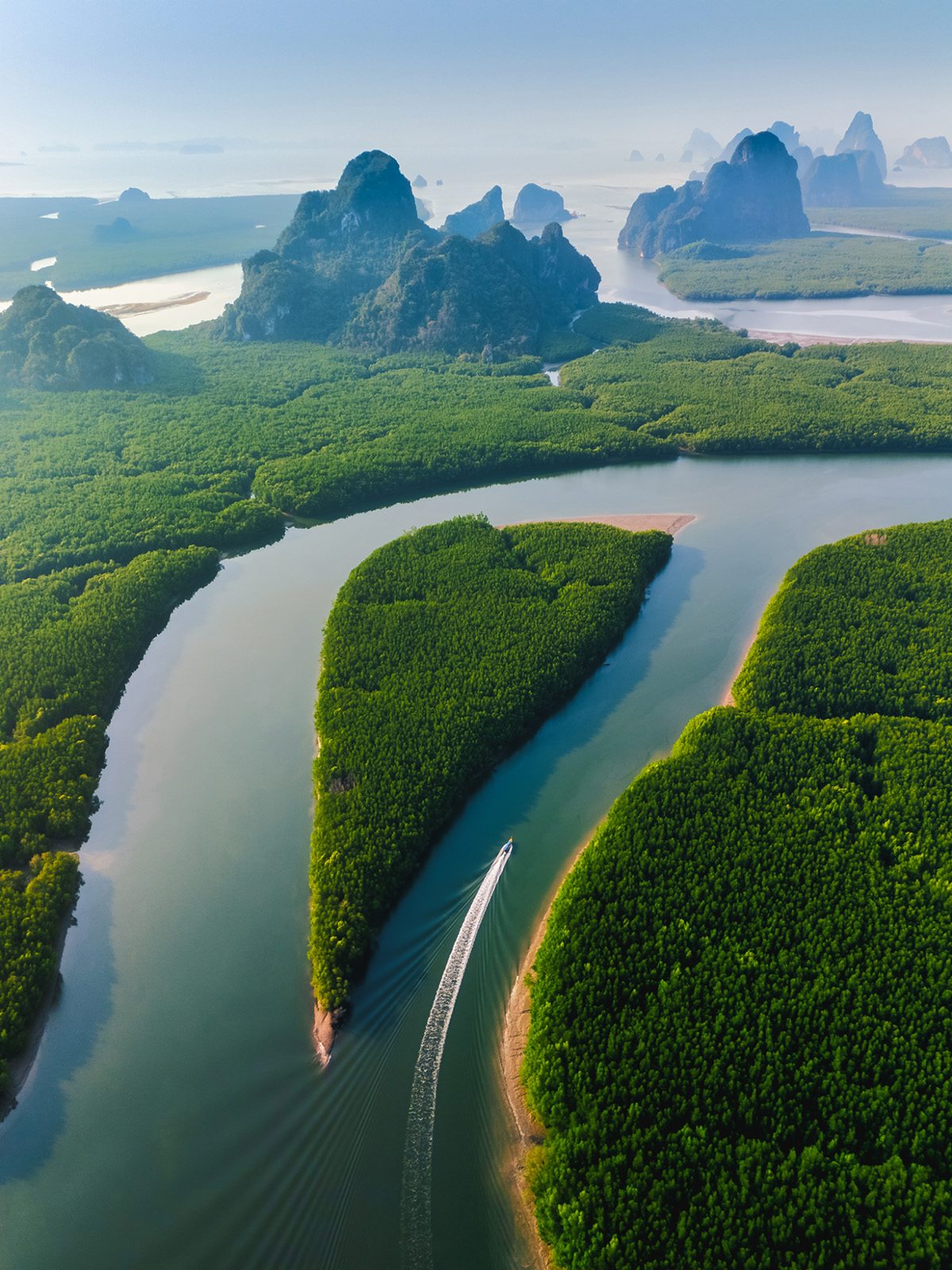 An aerial shot follows a boat as it cruises into Thailand's beautiful Phang Nga Bay. Copyright: © Kiyoshi Hijiki, Thailand, Winner, National Awards, Sony World Photography Awards 2025